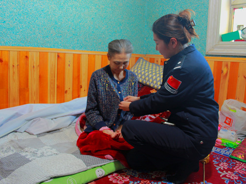 1772458379621917.jpg 图为户籍民警为老人整理衣服.jpg